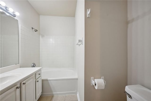 full bathroom featuring tiled shower / bath, tile patterned flooring, vanity, and toilet