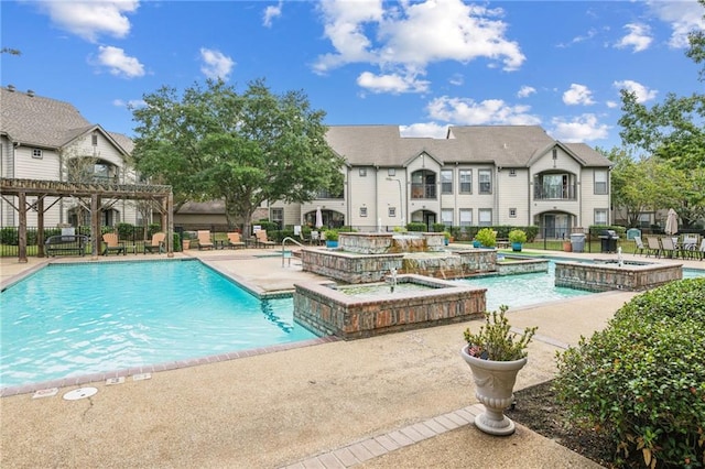 view of pool with pool water feature and a patio