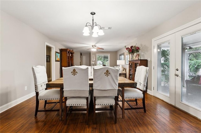 dining room with dark hardwood / wood-style flooring and ceiling fan with notable chandelier