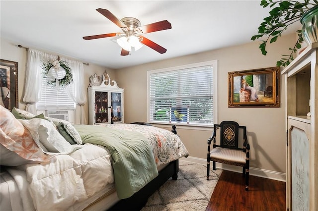 bedroom featuring ceiling fan, hardwood / wood-style flooring, and cooling unit