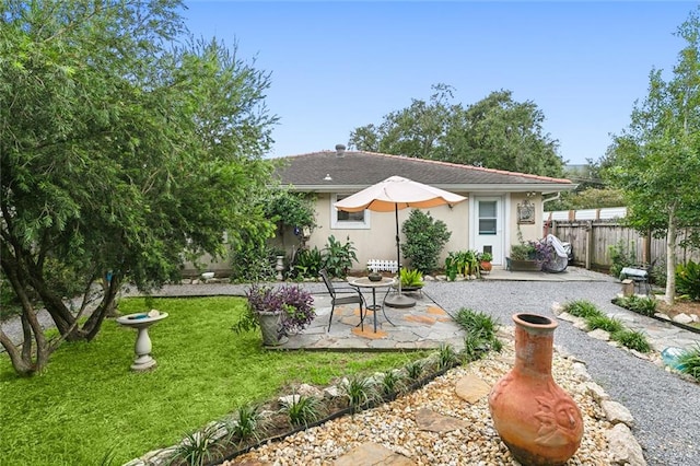 rear view of property with a patio and a lawn