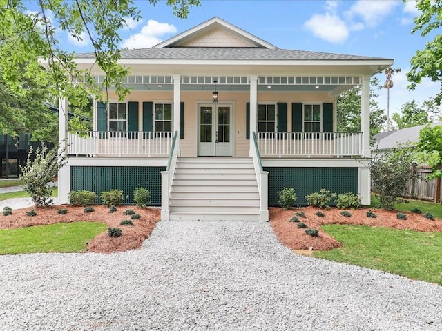 view of front facade with driveway, a shingled roof, stairway, french doors, and a porch