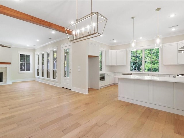 kitchen featuring light wood-style floors, white cabinetry, light countertops, and crown molding