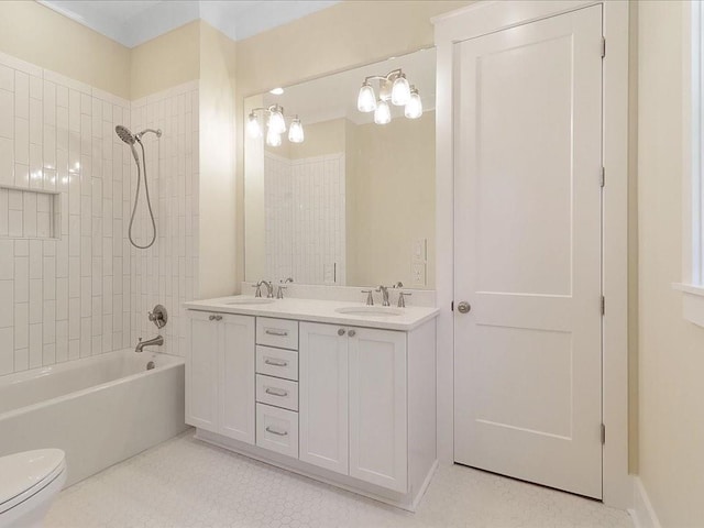 bathroom featuring toilet, double vanity, tub / shower combination, and a sink