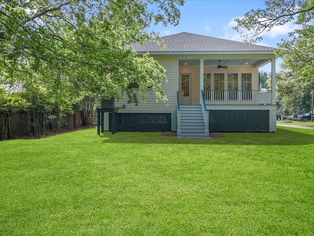 back of property with a shingled roof, fence, a lawn, and a ceiling fan