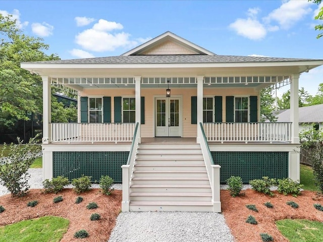 view of front facade with stairs, french doors, a porch, and roof with shingles