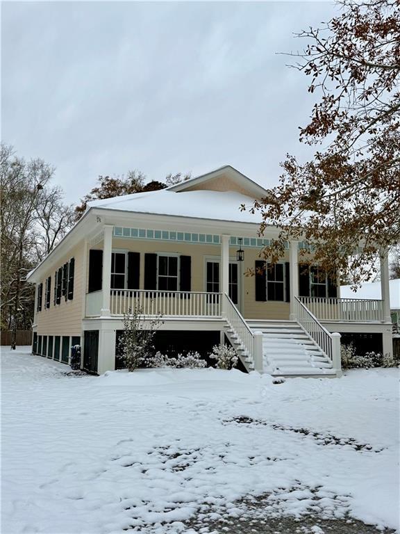 view of front of property with a garage, stairway, and a porch