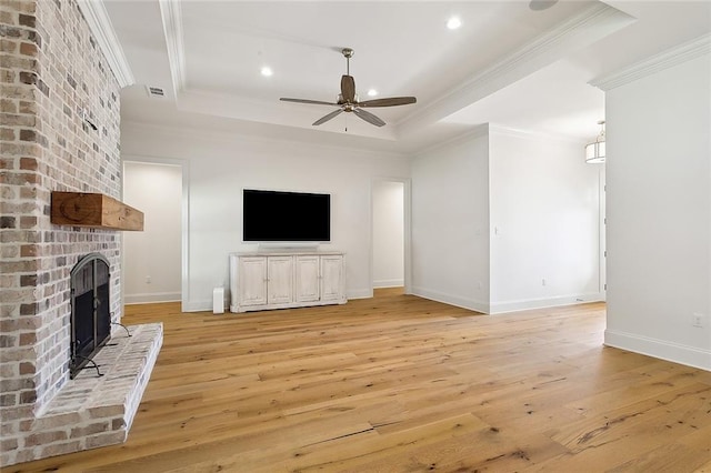 unfurnished living room with ceiling fan, a fireplace, light wood-type flooring, and crown molding