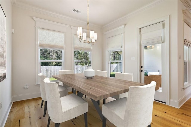 dining area with a chandelier, light hardwood / wood-style floors, and crown molding