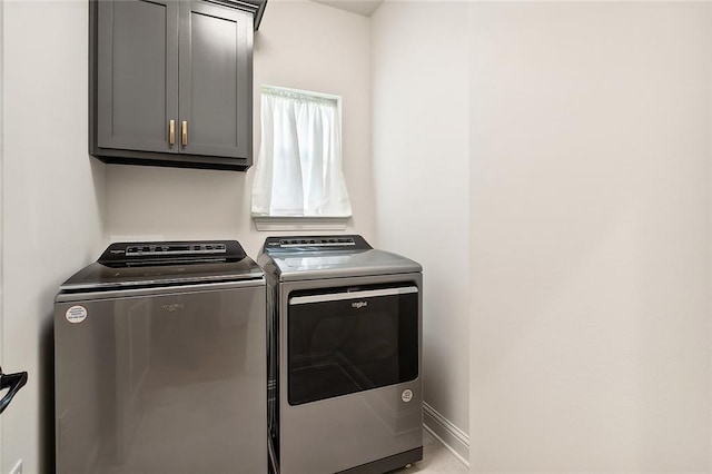 clothes washing area featuring washing machine and clothes dryer and cabinets