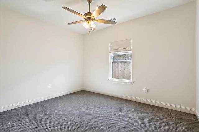 empty room with visible vents, dark carpet, baseboards, and ceiling fan