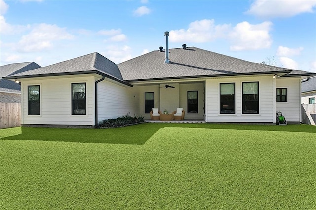 back of house featuring ceiling fan, a yard, roof with shingles, and fence