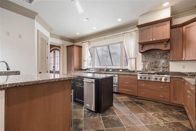 kitchen featuring decorative backsplash, dark stone counters, stainless steel gas cooktop, sink, and a kitchen island