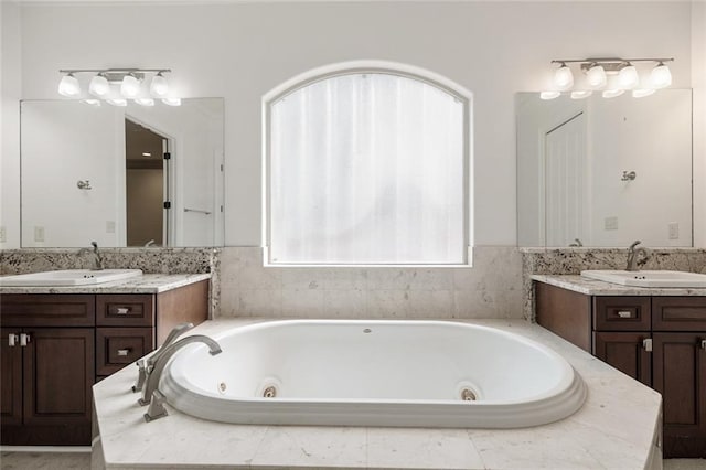 bathroom featuring vanity and tiled tub