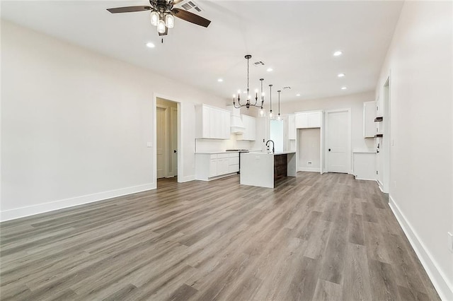 unfurnished living room featuring ceiling fan, sink, and light wood-type flooring