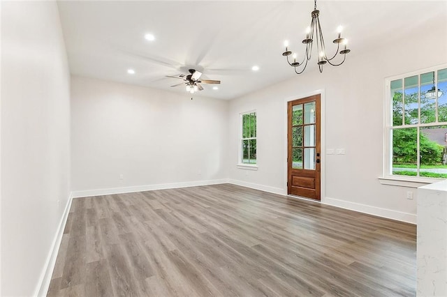 interior space with hardwood / wood-style flooring and ceiling fan with notable chandelier