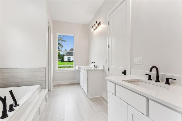 bathroom featuring vanity and tiled bath