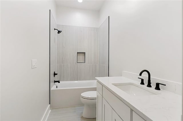 full bathroom featuring vanity, tiled shower / bath combo, and toilet