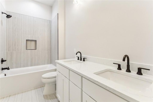 full bathroom featuring vanity, tiled shower / bath, and toilet