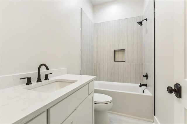 full bathroom with vanity, tiled shower / bath, and toilet