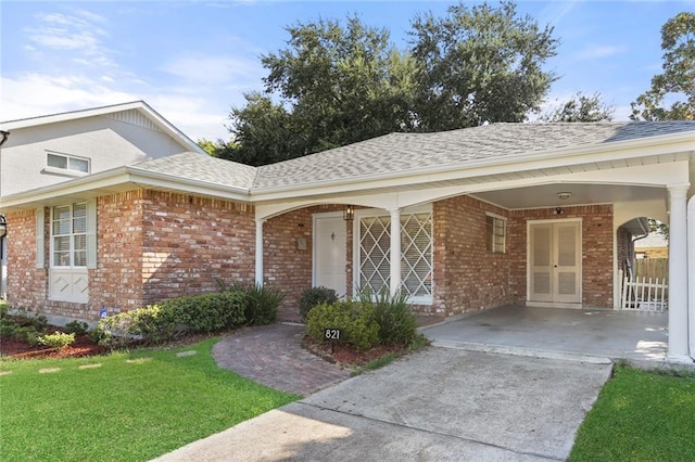 view of exterior entry featuring french doors and a yard