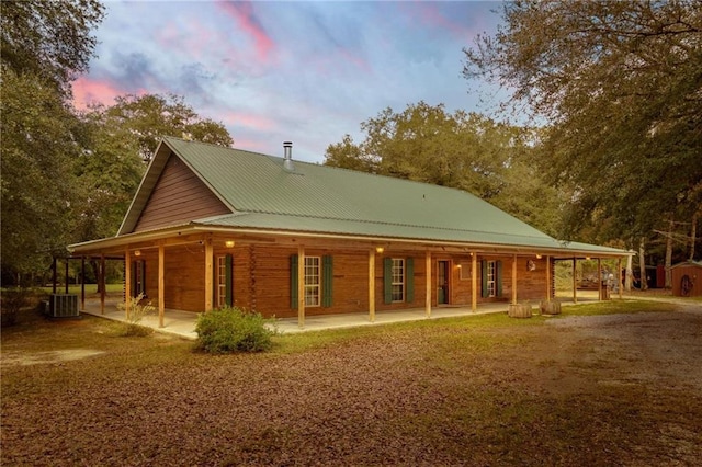 back house at dusk with a patio and central air condition unit