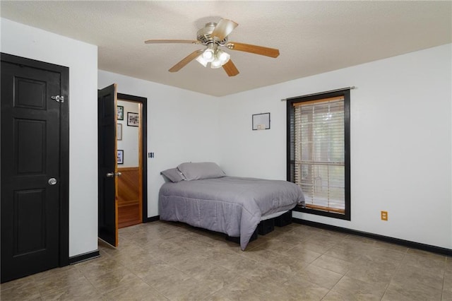 bedroom featuring ceiling fan and a textured ceiling