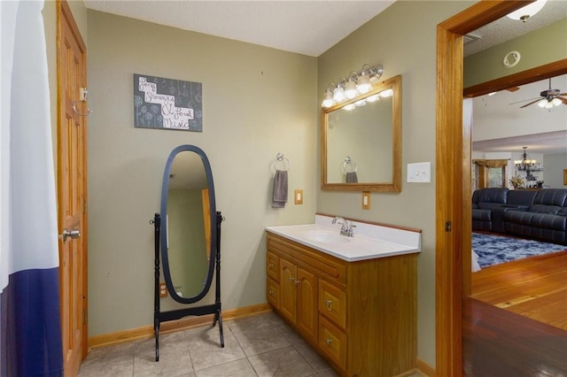 bathroom with vanity, ceiling fan with notable chandelier, and tile patterned flooring