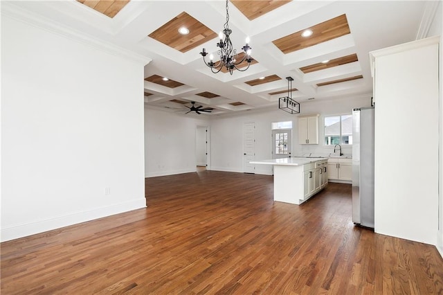 kitchen featuring beamed ceiling, hanging light fixtures, a center island, dark hardwood / wood-style flooring, and stainless steel refrigerator