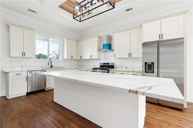 kitchen featuring a kitchen island, wall chimney range hood, dark hardwood / wood-style floors, sink, and appliances with stainless steel finishes