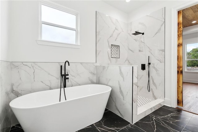 bathroom featuring tile walls and shower with separate bathtub