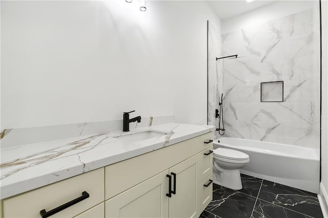 full bathroom featuring tiled shower / bath, vanity, and toilet