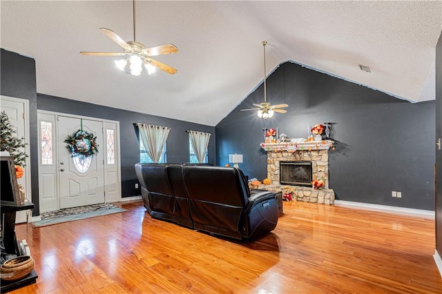 living room with hardwood / wood-style floors, a fireplace, high vaulted ceiling, and ceiling fan