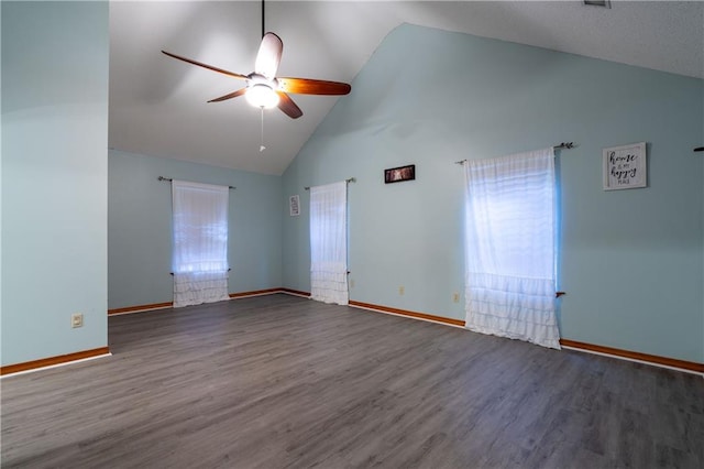 empty room featuring dark hardwood / wood-style floors, high vaulted ceiling, and ceiling fan