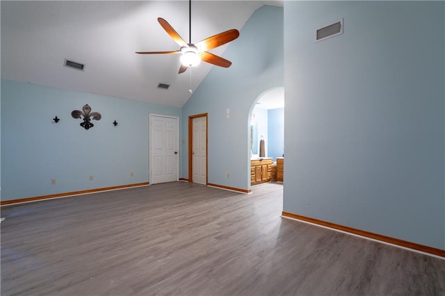 spare room featuring wood-type flooring, high vaulted ceiling, and ceiling fan