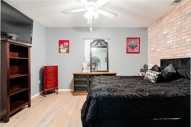 bedroom with light hardwood / wood-style flooring, a fireplace, and ceiling fan