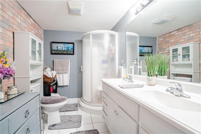 bathroom featuring a shower with door, brick wall, vanity, and toilet