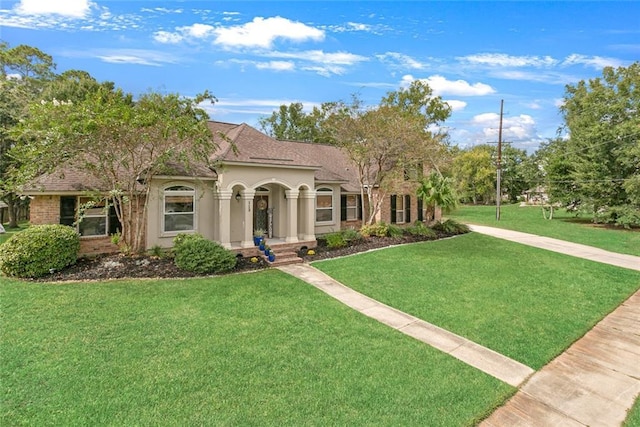 mediterranean / spanish home with a front lawn