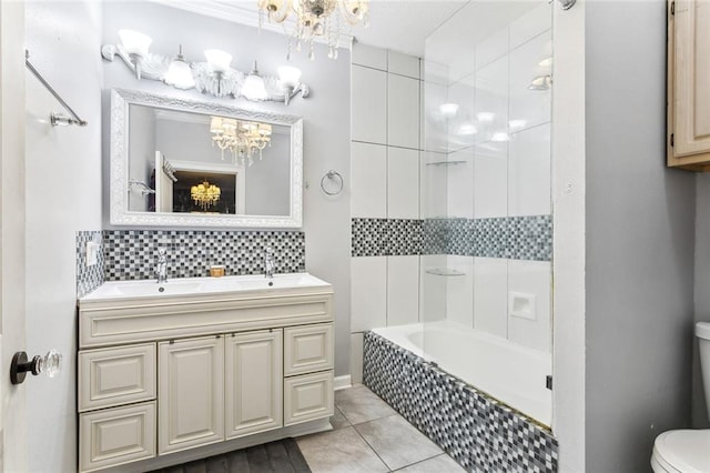 full bathroom with tiled shower / bath, toilet, vanity, a notable chandelier, and tile patterned floors