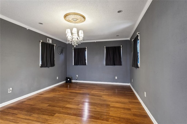 spare room featuring hardwood / wood-style flooring, ornamental molding, and a textured ceiling