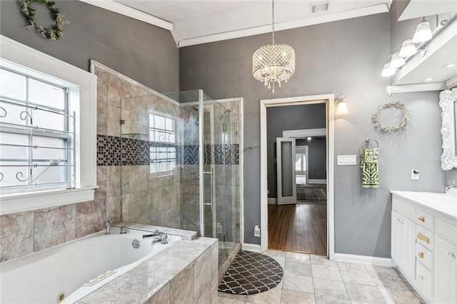 bathroom with plus walk in shower, hardwood / wood-style flooring, crown molding, an inviting chandelier, and vanity