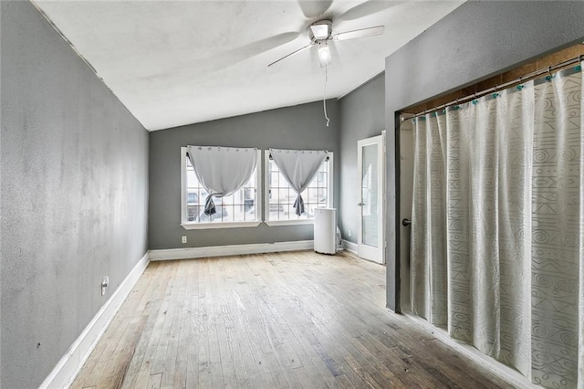 interior space with light hardwood / wood-style floors, ceiling fan, and vaulted ceiling