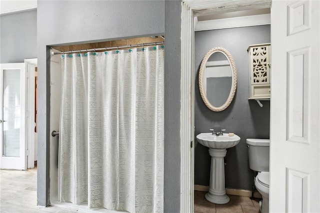 bathroom with toilet and tile patterned flooring