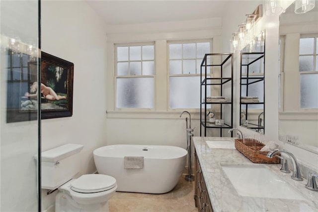 bathroom with vanity, a healthy amount of sunlight, toilet, and a tub to relax in