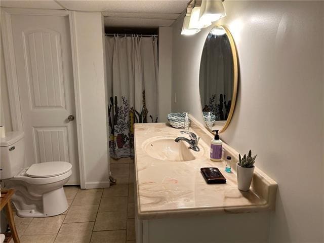 bathroom with toilet, vanity, and tile patterned floors