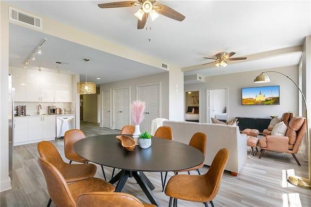 dining area with light hardwood / wood-style floors, ceiling fan, and sink