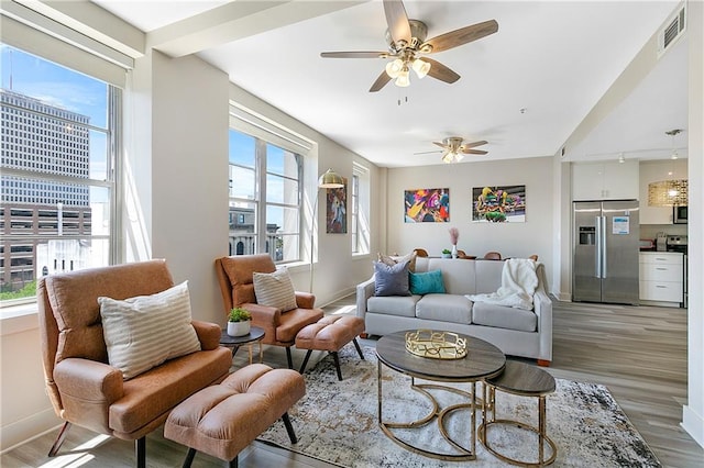 living room with ceiling fan, wood-type flooring, and plenty of natural light