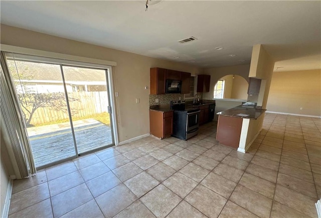 kitchen featuring decorative backsplash, sink, plenty of natural light, and electric stove