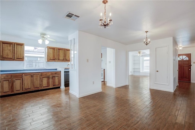 kitchen featuring ceiling fan with notable chandelier, wood-type flooring, and hanging light fixtures