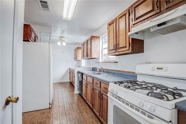 kitchen with ceiling fan, white appliances, sink, and light hardwood / wood-style flooring